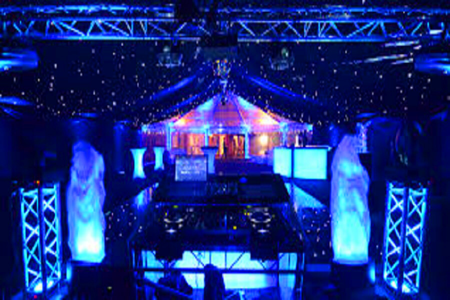 Outdoor event setup with party tents, tables, chairs, stage, lighting and sound systems for celebration in Delhi NCR